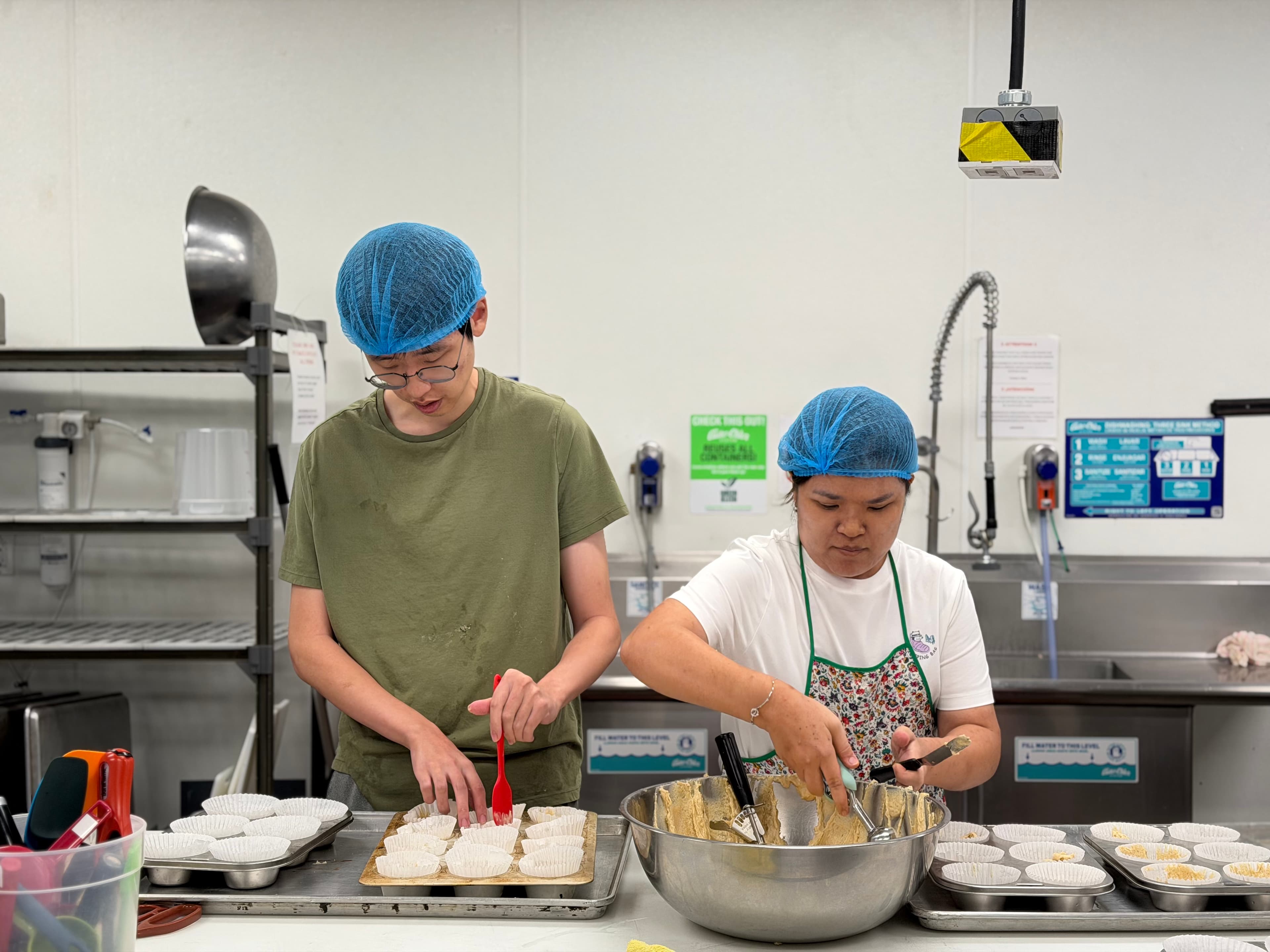 Students Chris and Jane baking products for the market. 