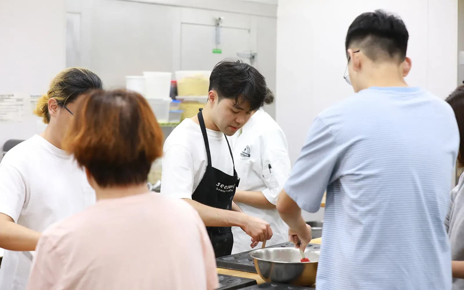Seesaw students and staff baking together in the kitchen.