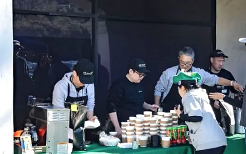 Seesaw student baristas serving coffee from the green Seesaw table at a community event.