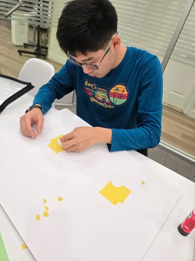 A Seesaw student working on a paper-collage art project.