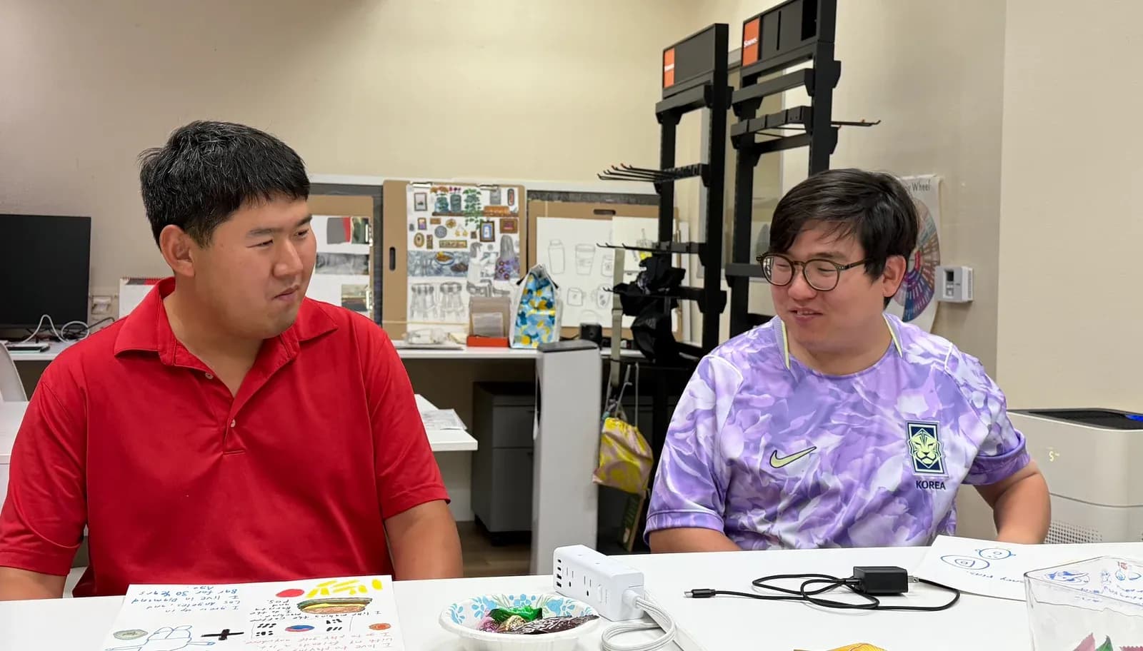 Two people seated together at a table during a Seesaw program activity.